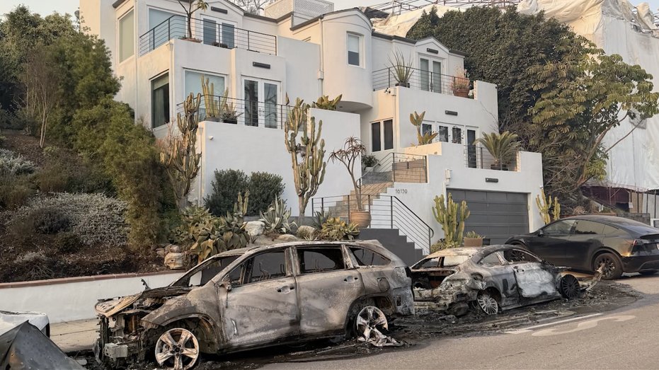 Burning cars in front of a house