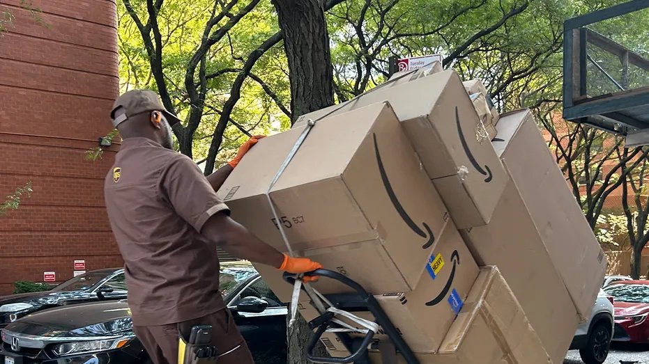 A worker transports packages on the sidewalk
