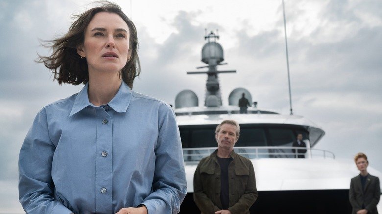 Lo stands at the front of the ship with Richard Bulmer behind her in The Woman in Cabin 10