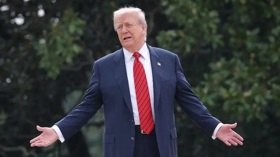 US President Donald Trump stands with his arms open while speaking to reporters