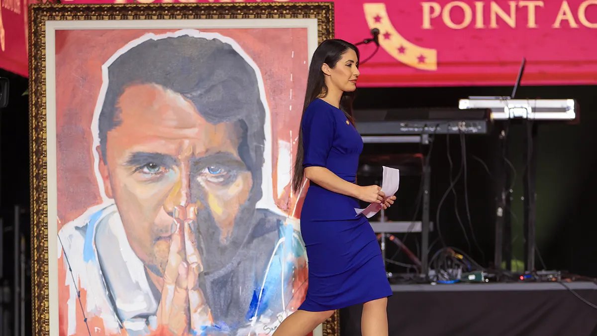 Anna Paulina Luna walks past a picture of Charlie