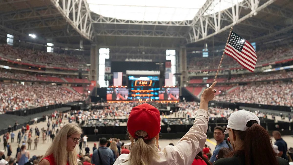 Mourners wave the flag at Charlie Kirk's memorial service