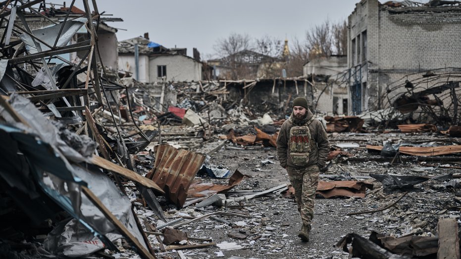 A soldier walks through a destroyed Ukrainian city