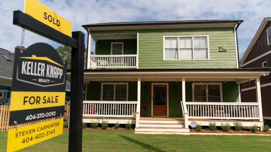 House with a for sale sign in the front