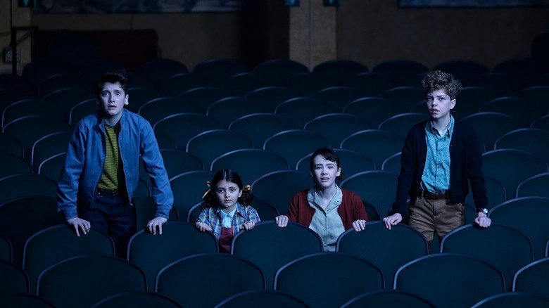 Clara Stack as Lily, Michal Karim Fiedler as Teddy, Jacques Molloy Legault as Phil, and Hunter Storm Baker as a terrified-looking Suze in a movie theater on It: Welcome to Derry.