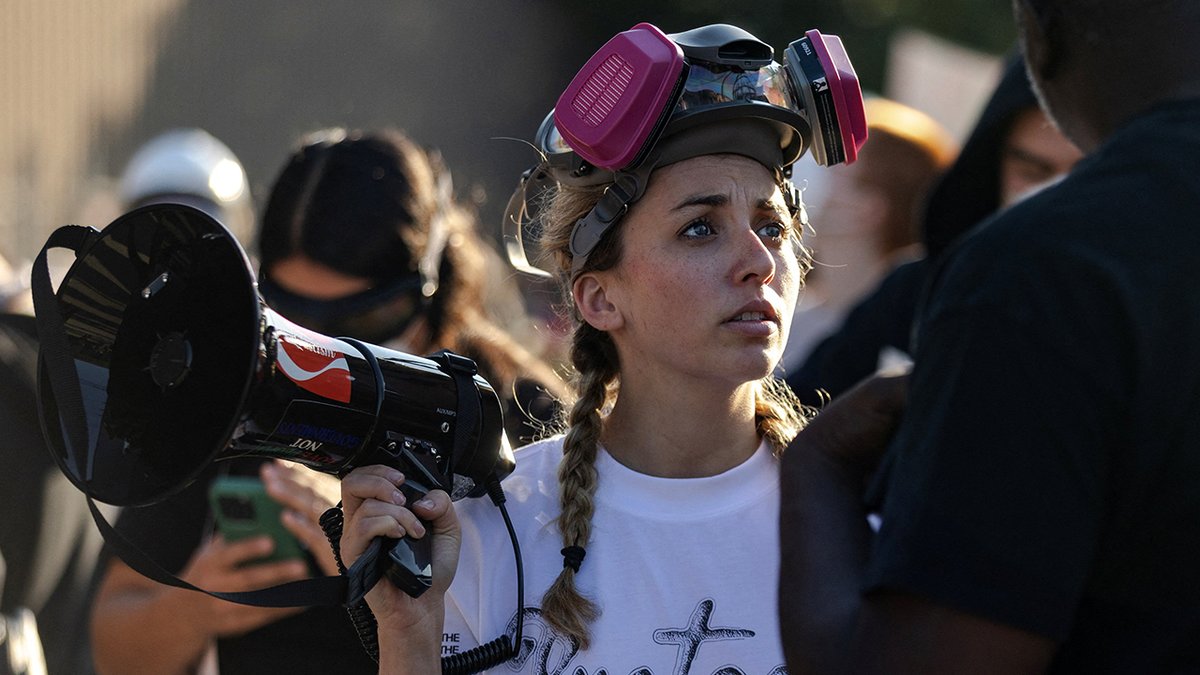 Kat Abu-Ghazaleh holds a megaphone at an anti-ICE demonstration