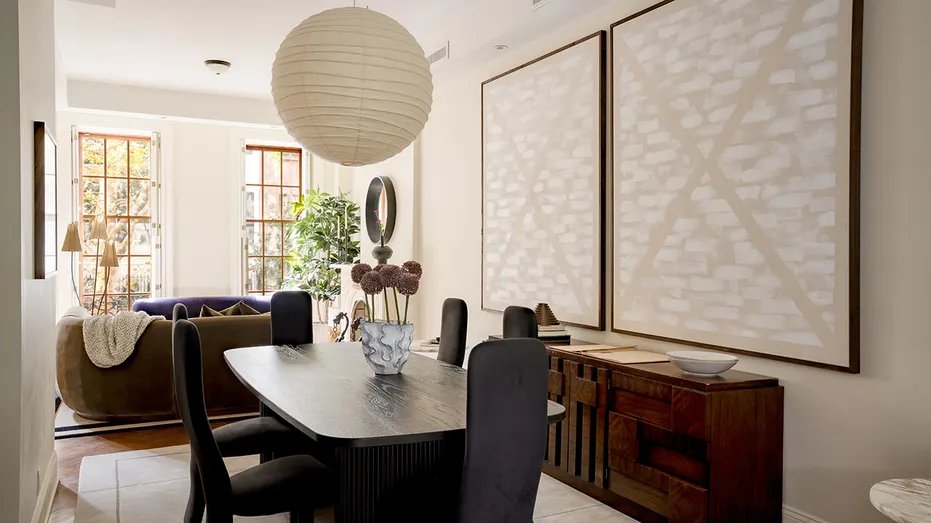 The dining room features paintings on the walls and unique light fixtures.