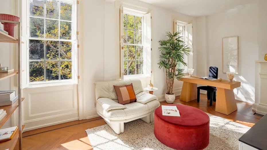 The spacious office features colorful furniture and a wooden desk.