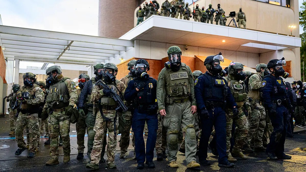 Federal agents stand outside an ICE facility in Portland, Oregon.