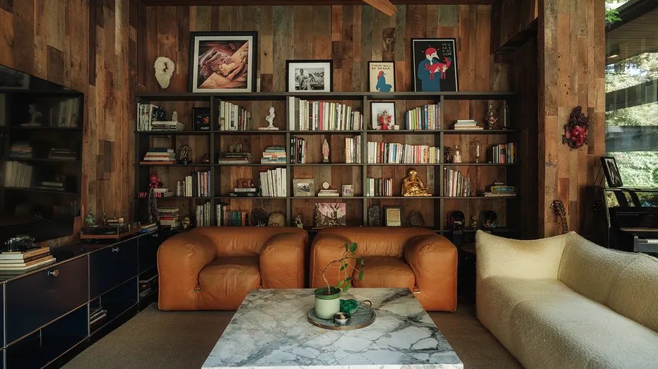 The house has a room with built-in shelves and a TV.