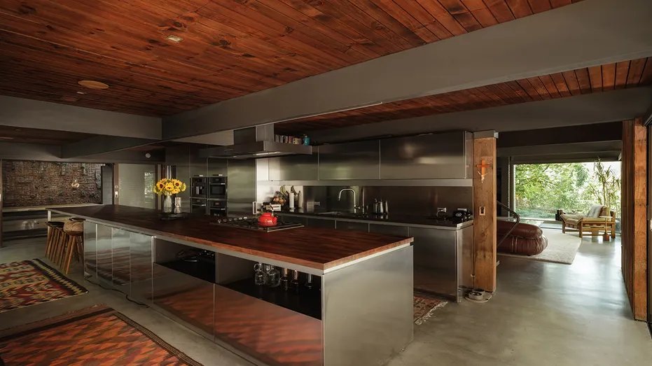 The kitchen features a large center island and wood ceiling.