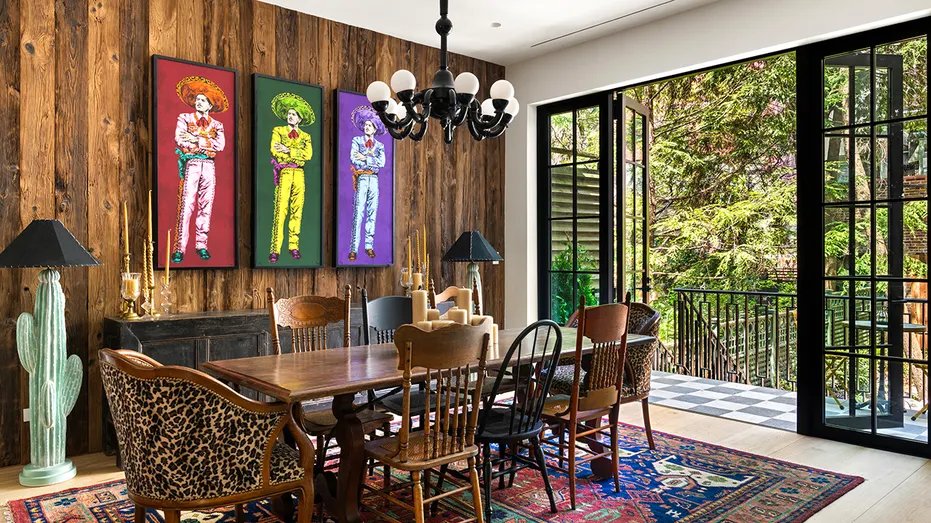The dining room features colorful pictures on the wall and access to the outside.