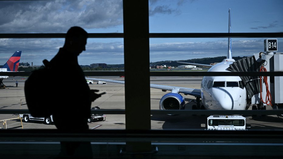 A man checks the phone at Reagan National Airport amid the government shutdown