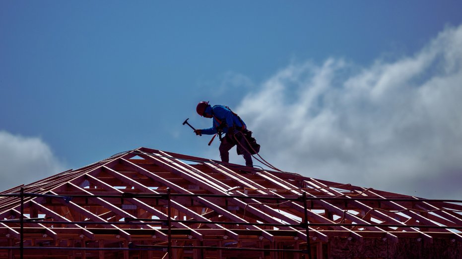 A worker on the roof of a new house under construction in California.