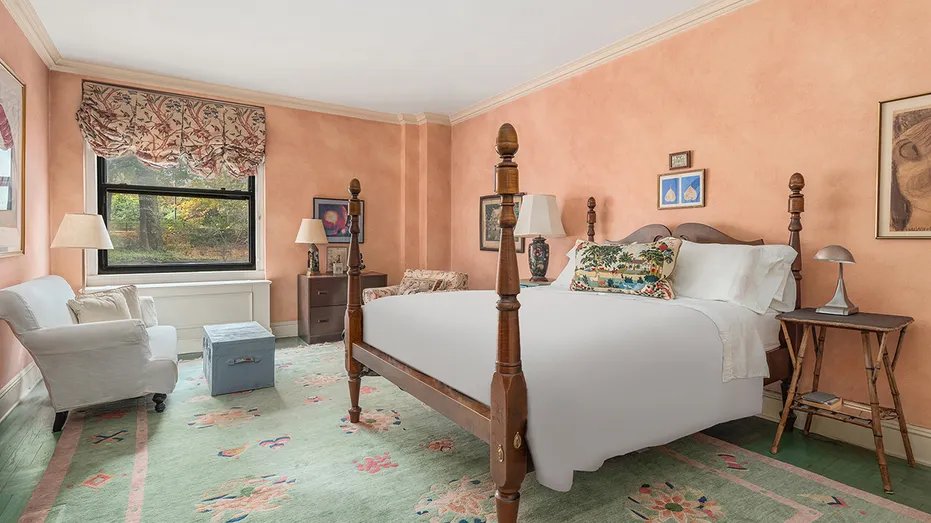 Bedroom with pink walls and white bed.