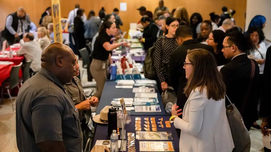 Job seekers and recruiters speak at a career fair