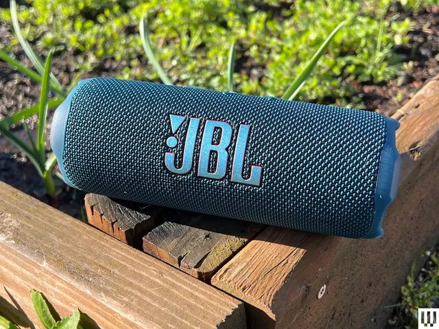 Front view of J.B.L. Flip 7 Bluetooth Speaker sitting on wooden edge of garden box.