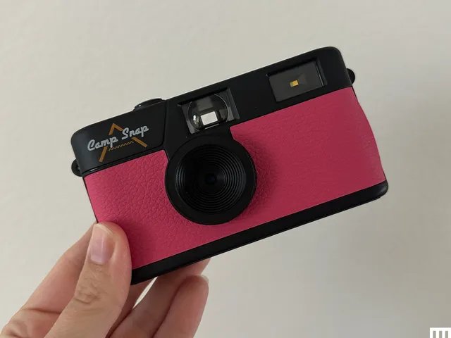 Hand holding a pink Camp Snap digital camera