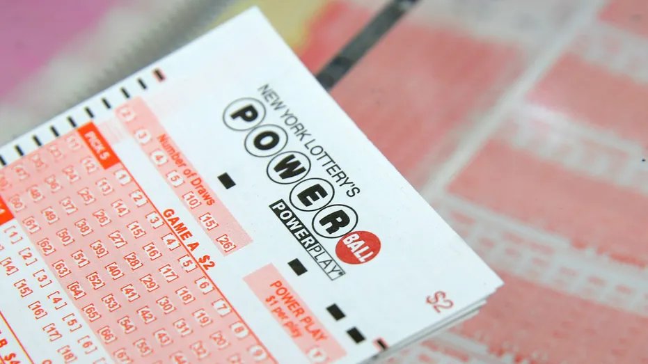 A Powerball lottery ticket lies on a table in a store