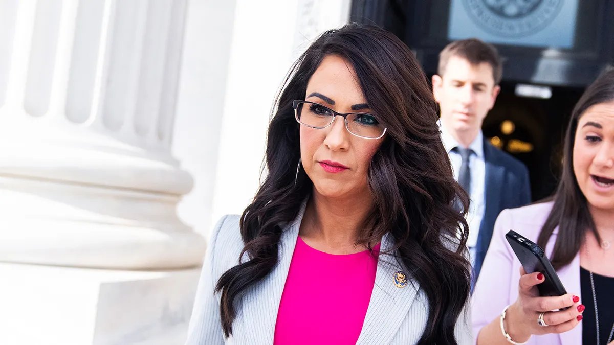 Rep. Lauren Boebert, a woman with glasses, long dark brown hair and a pink shirt, exits the U.S. Capitol