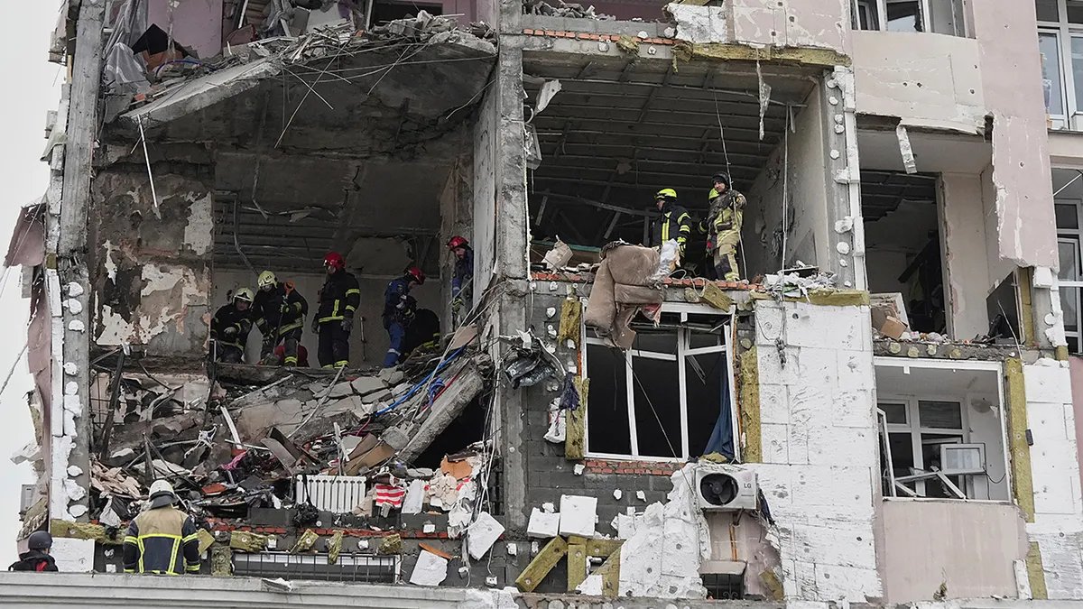 Rescuers look at the wreckage inside an apartment building damaged in the Ukrainian war