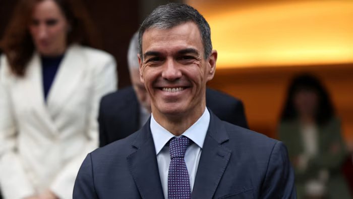 Pedro Sanchez smiles while taking a group photo with members of the government before the final Cabinet meeting of the year.