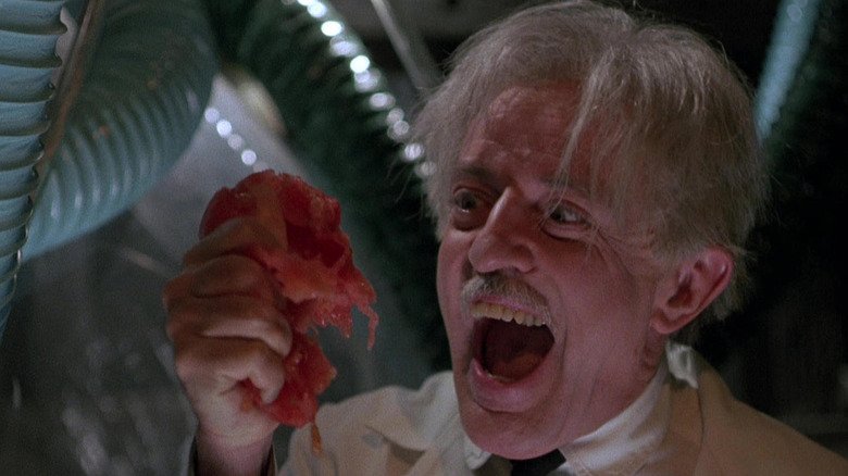John Astin as Professor Gangrene crushing tomatoes in his hand in the movie 