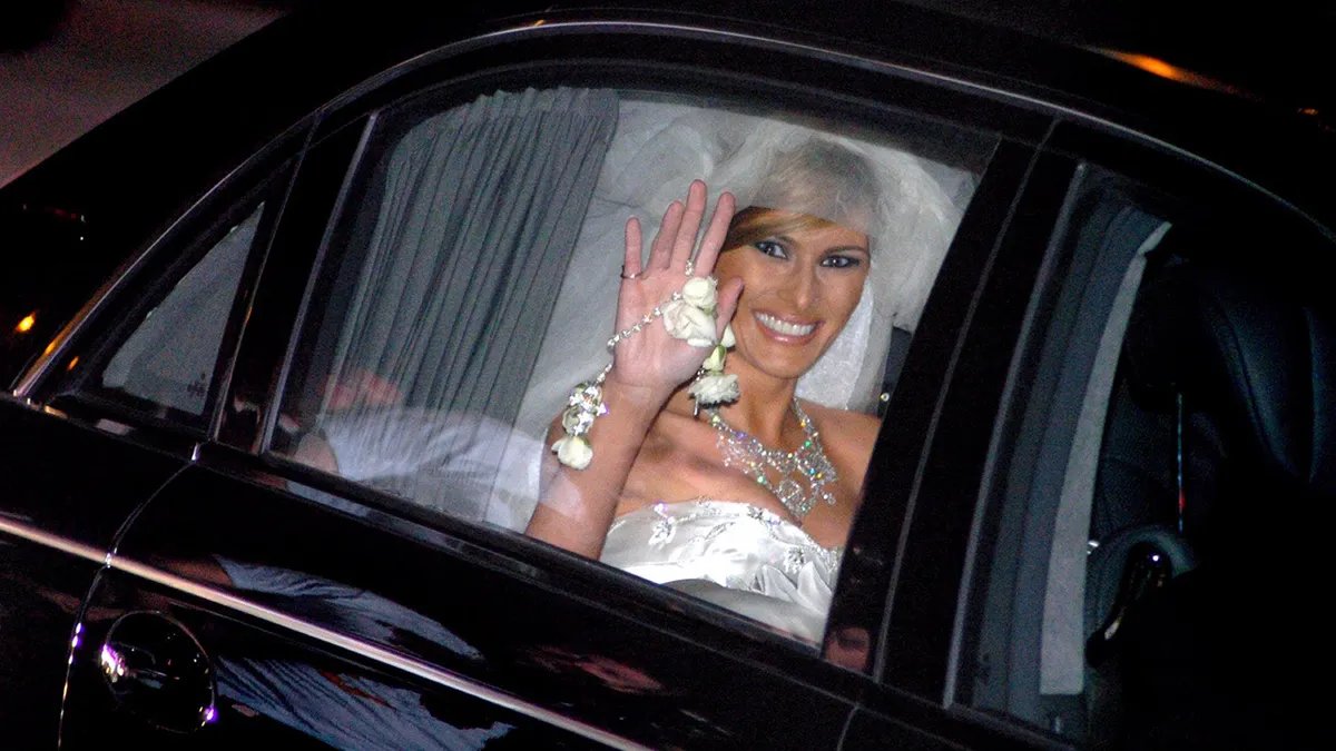 Melania Trump in her wedding dress waves after her marriage to Donald Trump