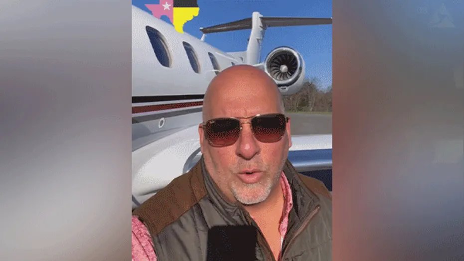 Todd Burkhalter speaks on the phone in front of a private plane