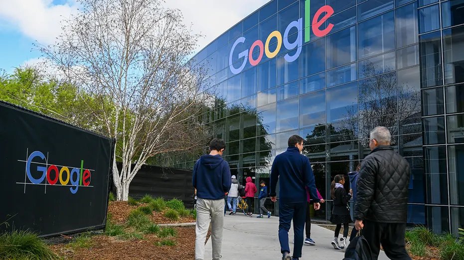 Employees walk into the Google building