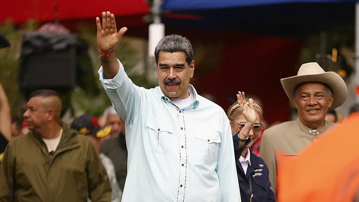 Venezuelan President Nicolas Maduro raises his hand during a rally in Caracas